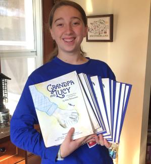 Author Edie Weinstein holding copies of her book, "Grandpa and Lucy"